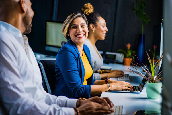 happy man and woman sitting at computers